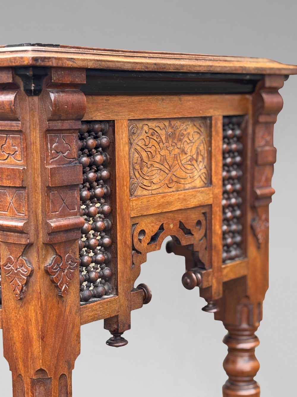 A late 19th-century Aesthetic Movement side table featuring carved wood, a central mother-of-pearl inlay medallion, turned spindle side panels, and turned legs. View XII