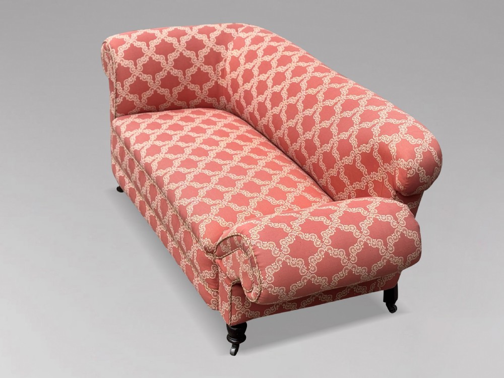A 19th-century Victorian upholstered sofa featuring terracotta and cream patterned fabric, rolled arms, and dark turned wooden legs on brass castors. View VIII