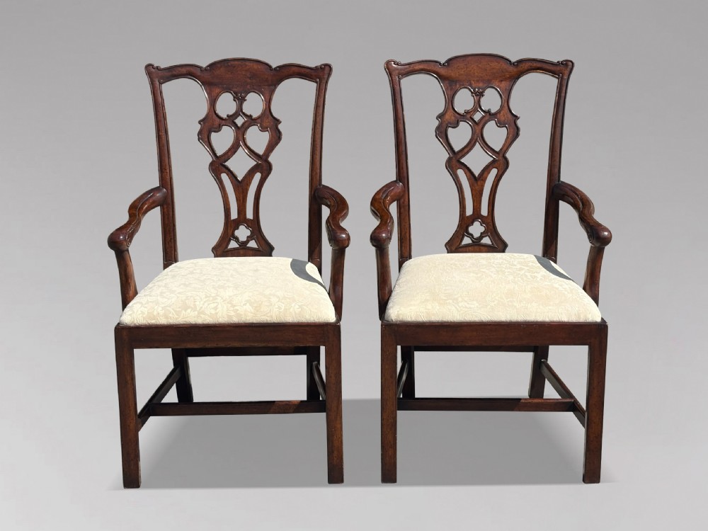 A set of six Edwardian mahogany dining chairs featuring pierced carved back splats, serpentine top rails, cream upholstered seats, and straight square legs with H-stretchers. View II