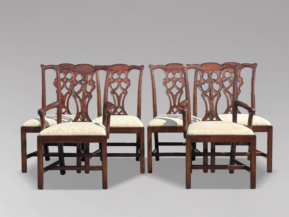 A set of six Edwardian mahogany dining chairs featuring pierced carved back splats, serpentine top rails, cream upholstered seats, and straight square legs with H-stretchers. View XII