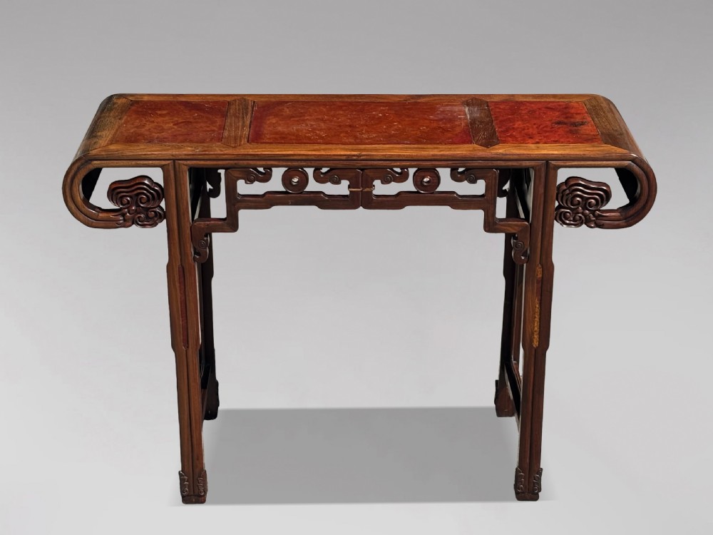 A late nineteenth-century Chinese Hongmu altar table featuring everted flange ends, decorative openwork carved aprons, and three amboyna wood panels inlaid on the top surface.
