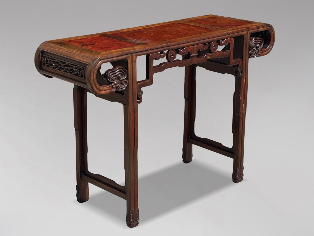 A late nineteenth-century Chinese Hongmu altar table featuring everted flange ends, decorative openwork carved aprons, and three amboyna wood panels inlaid on the top surface. View II