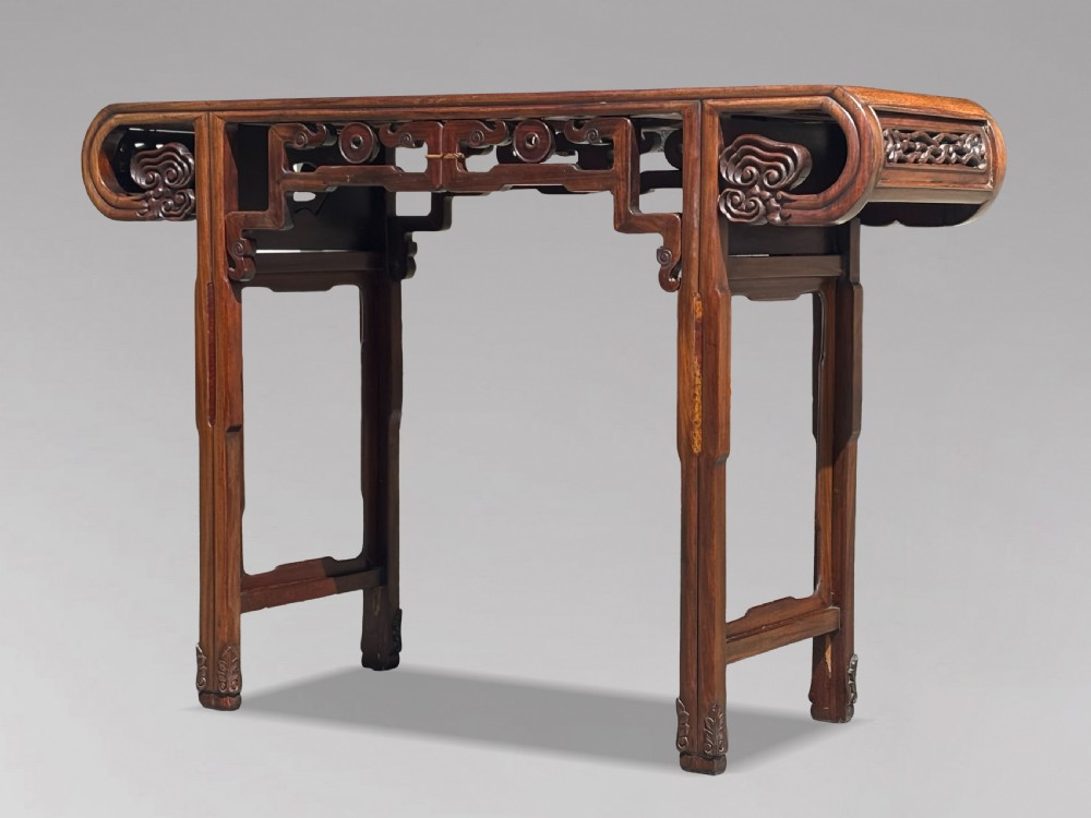 A late nineteenth-century Chinese Hongmu altar table featuring everted flange ends, decorative openwork carved aprons, and three amboyna wood panels inlaid on the top surface. View III