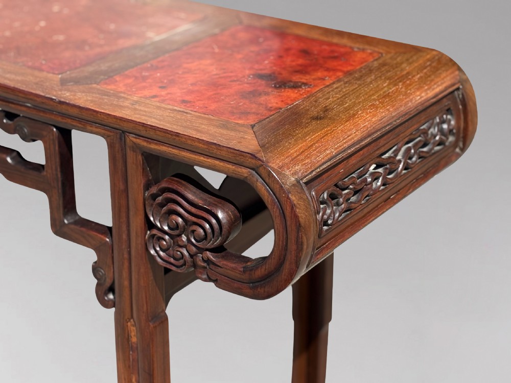 A late nineteenth-century Chinese Hongmu altar table featuring everted flange ends, decorative openwork carved aprons, and three amboyna wood panels inlaid on the top surface. View V