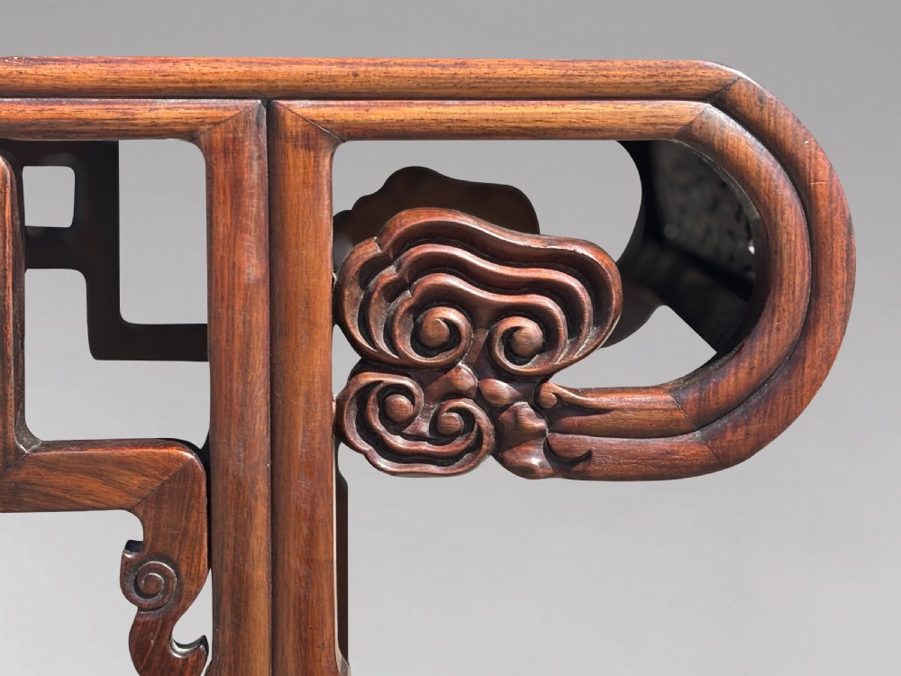 A late nineteenth-century Chinese Hongmu altar table featuring everted flange ends, decorative openwork carved aprons, and three amboyna wood panels inlaid on the top surface. View VI