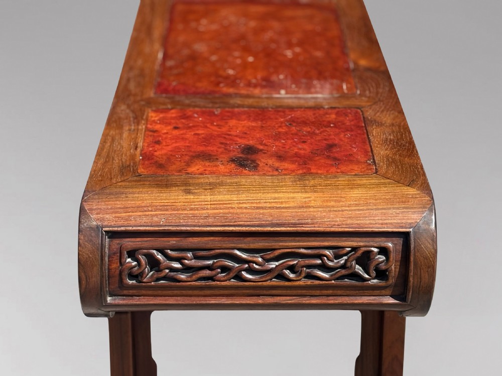 A late nineteenth-century Chinese Hongmu altar table featuring everted flange ends, decorative openwork carved aprons, and three amboyna wood panels inlaid on the top surface. View X
