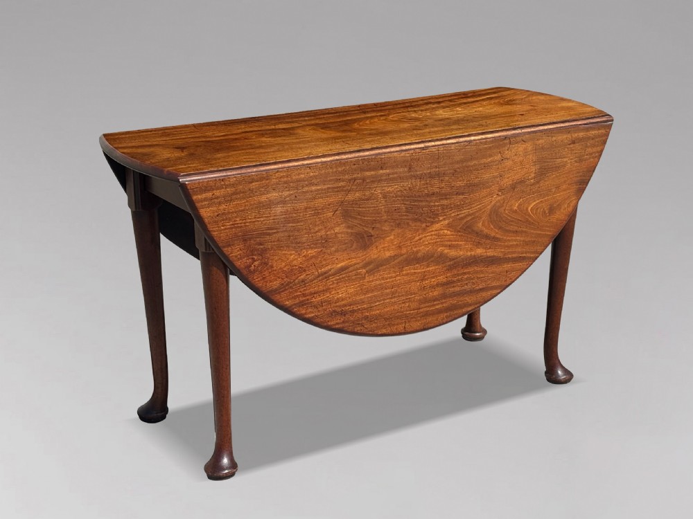 An 18th-century George II mahogany drop-leaf dining table with a round top and tapered legs ending in pad feet. View V