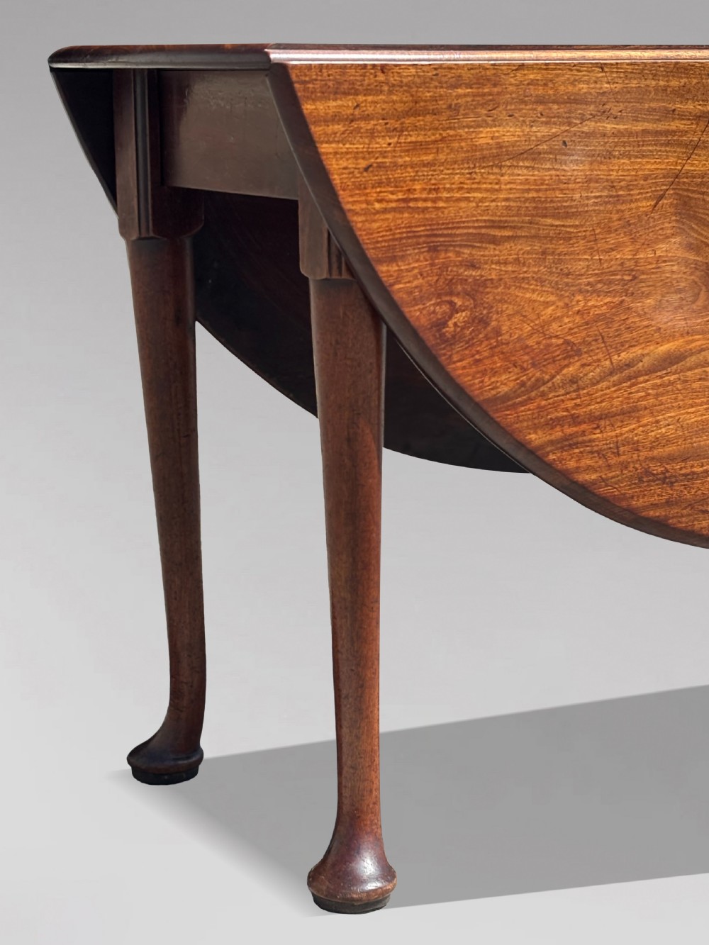 An 18th-century George II mahogany drop-leaf dining table with a round top and tapered legs ending in pad feet. View VI
