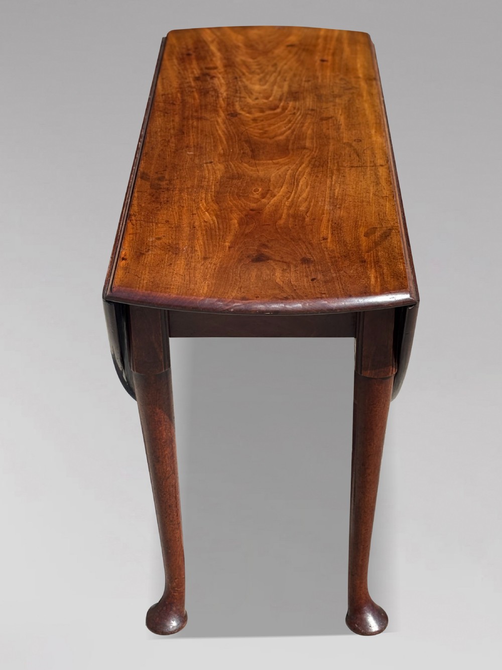 An 18th-century George II mahogany drop-leaf dining table with a round top and tapered legs ending in pad feet. View VII