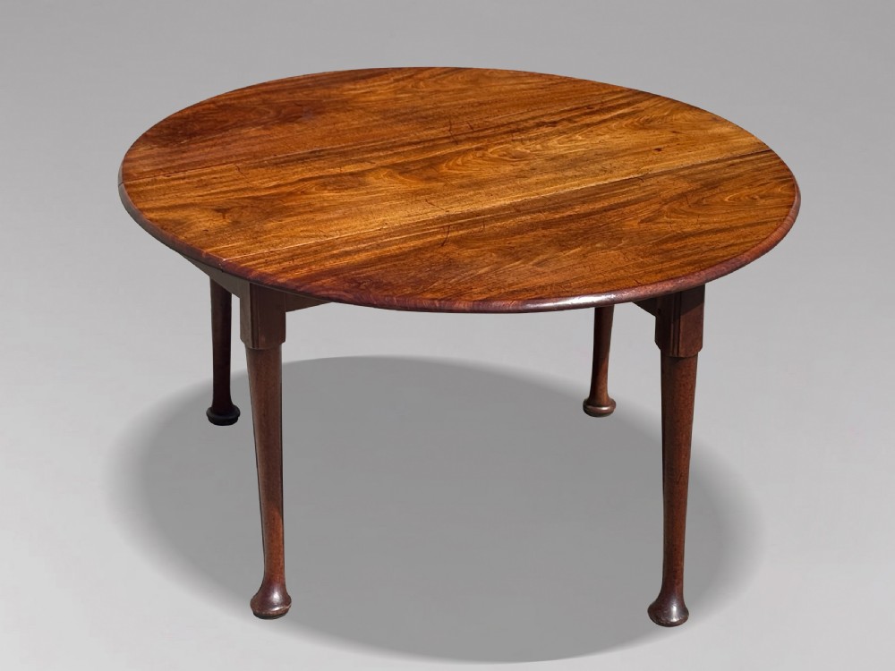An 18th-century George II mahogany drop-leaf dining table with a round top and tapered legs ending in pad feet. View VIII