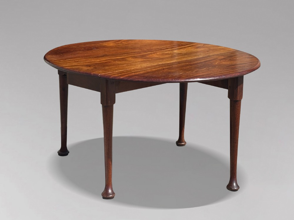 An 18th-century George II mahogany drop-leaf dining table with a round top and tapered legs ending in pad feet. View IX
