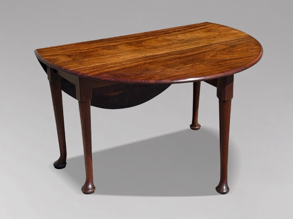 An 18th-century George II mahogany drop-leaf dining table with a round top and tapered legs ending in pad feet. View X