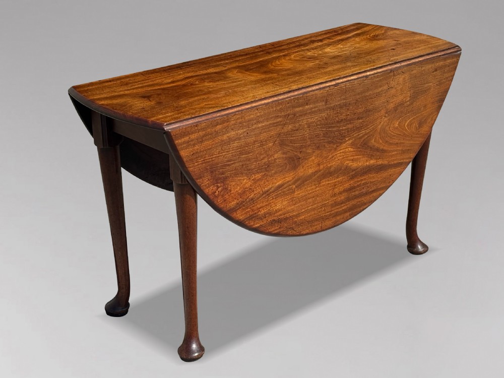 An 18th-century George II mahogany drop-leaf dining table with a round top and tapered legs ending in pad feet. View XI