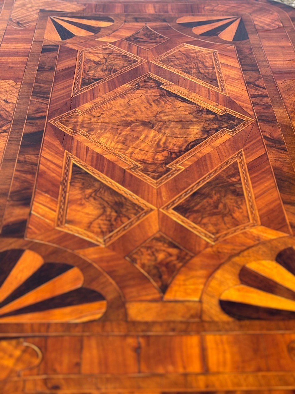 An 18th-century Maltese walnut cabinet with geometric parquetry inlays on the top and two panelled doors flanked by rounded corners on turned feet. View IV