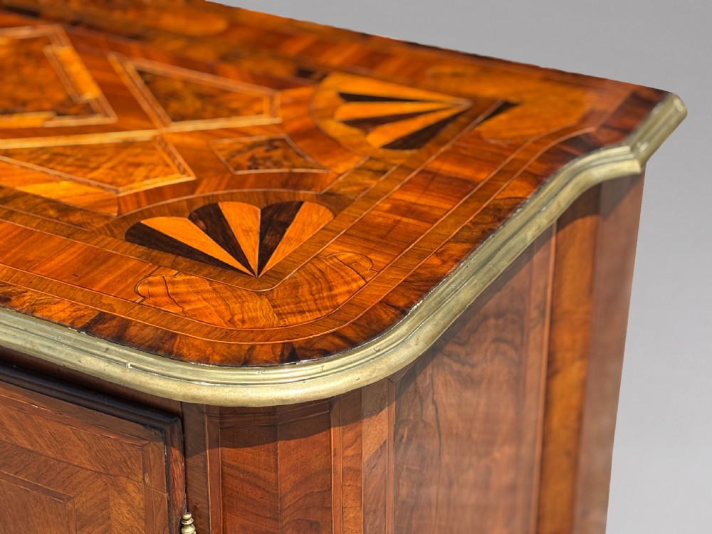 An 18th-century Maltese walnut cabinet with geometric parquetry inlays on the top and two panelled doors flanked by rounded corners on turned feet. View VIII
