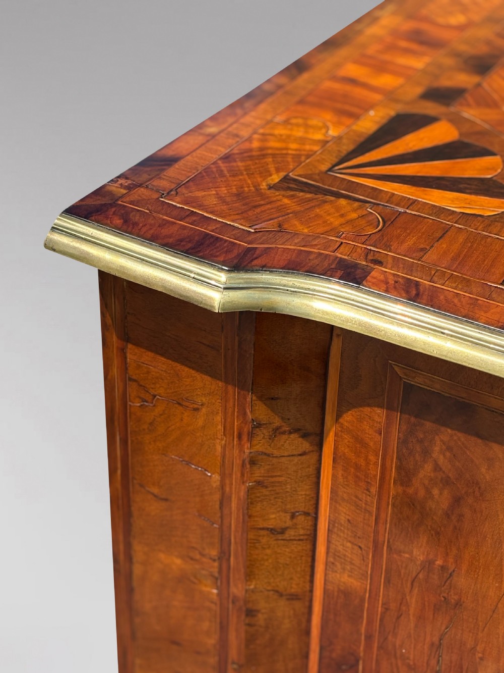 An 18th-century Maltese walnut cabinet with geometric parquetry inlays on the top and two panelled doors flanked by rounded corners on turned feet. View IX