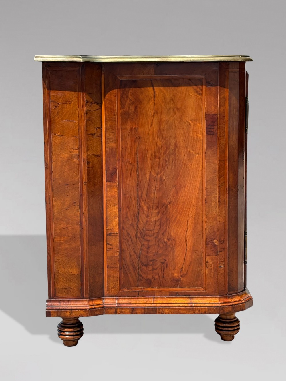 An 18th-century Maltese walnut cabinet with geometric parquetry inlays on the top and two panelled doors flanked by rounded corners on turned feet. View X