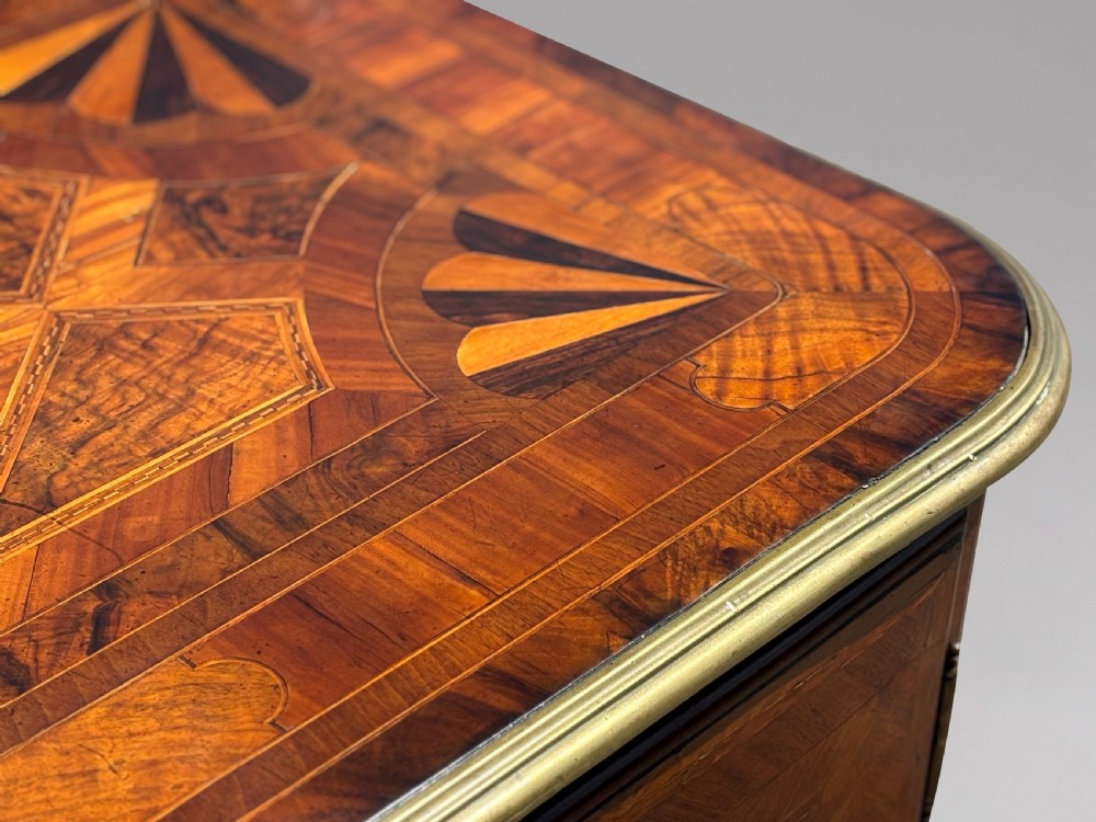 An 18th-century Maltese walnut cabinet with geometric parquetry inlays on the top and two panelled doors flanked by rounded corners on turned feet. View XIII