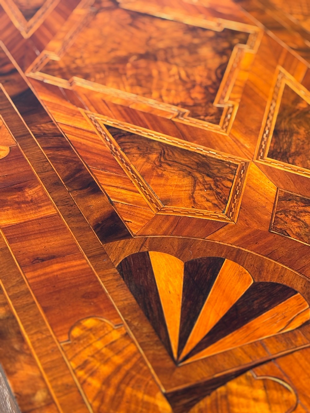 An 18th-century Maltese walnut cabinet with geometric parquetry inlays on the top and two panelled doors flanked by rounded corners on turned feet. View XV