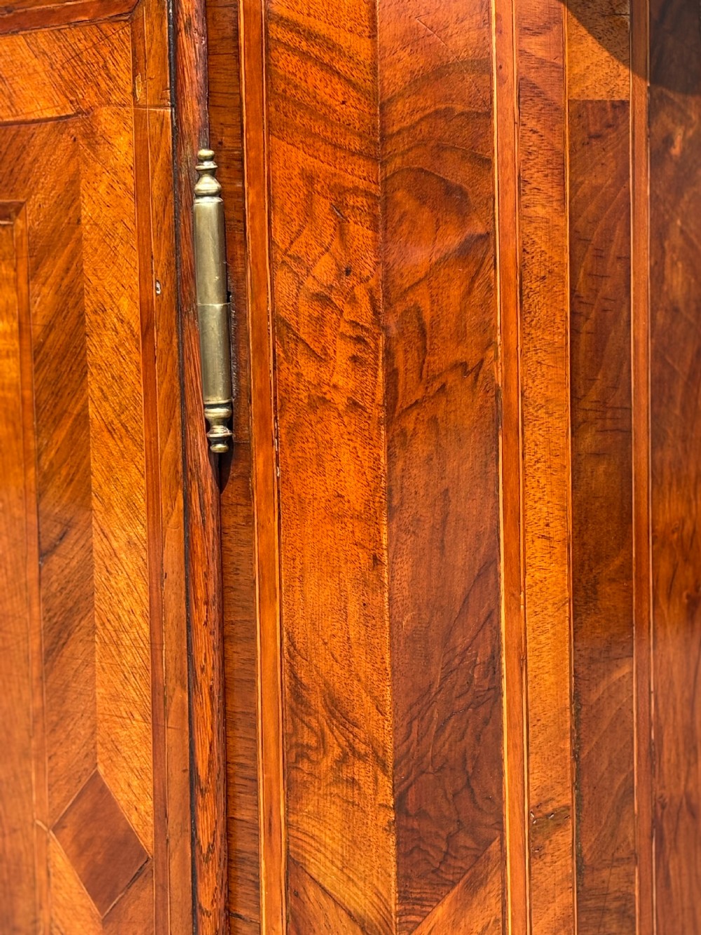An 18th-century Maltese walnut cabinet with geometric parquetry inlays on the top and two panelled doors flanked by rounded corners on turned feet. View XVII