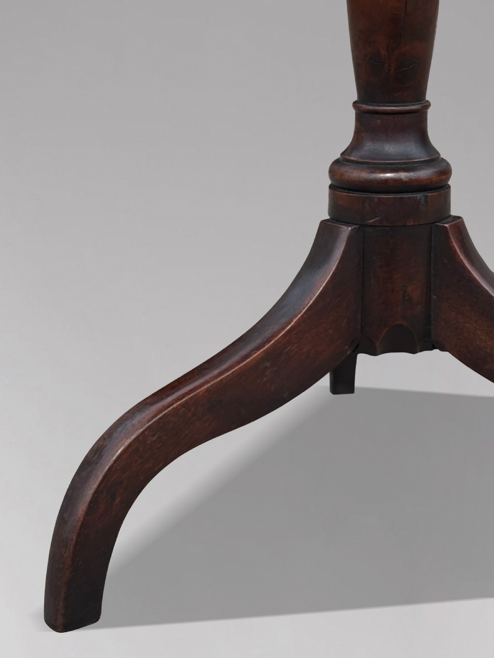 An 18th-century George III dark mahogany tripod table featuring a turned central stem and a top with canted corners. View V