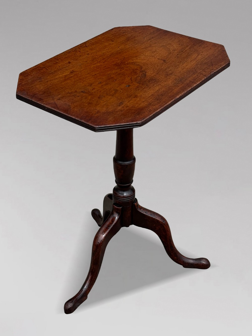 An 18th-century George III mahogany tripod table featuring an octagonal top, a central turned column, and three cabriole legs. View II