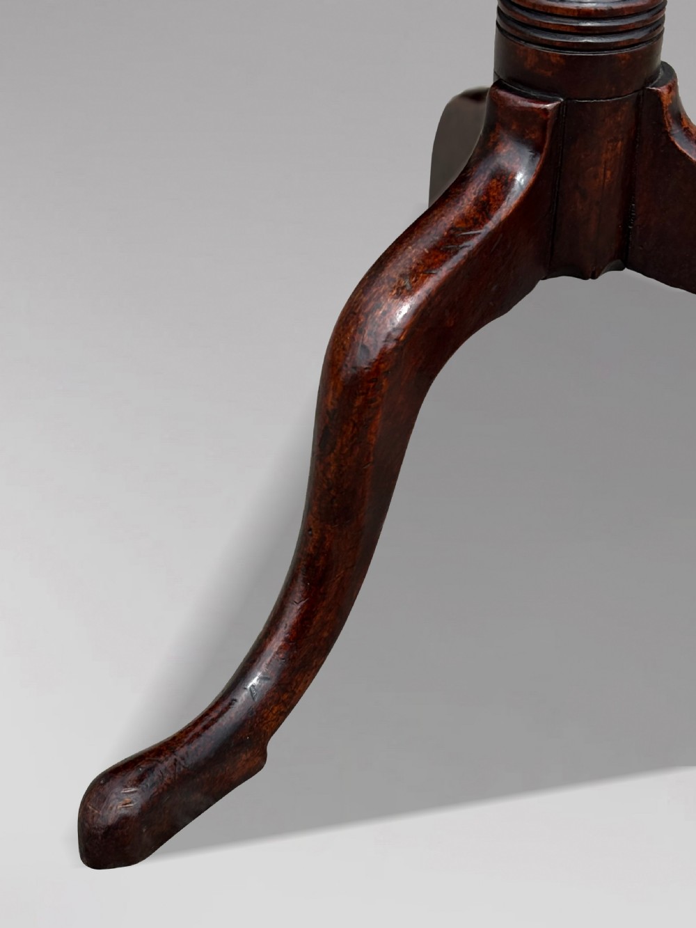 An 18th-century George III mahogany tripod table featuring an octagonal top, a central turned column, and three cabriole legs. View IV