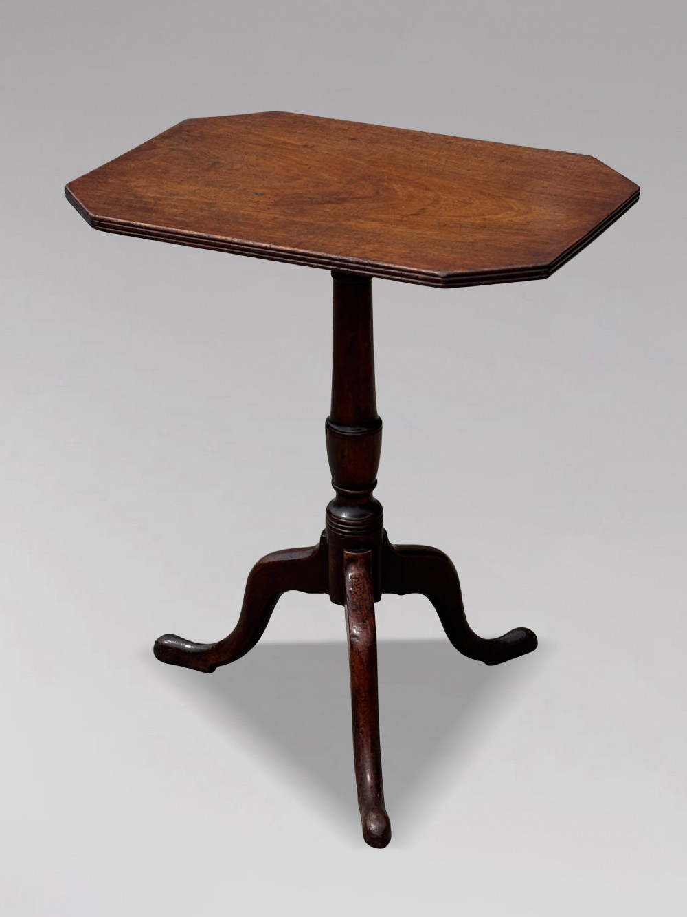 An 18th-century George III mahogany tripod table featuring an octagonal top, a central turned column, and three cabriole legs. View V