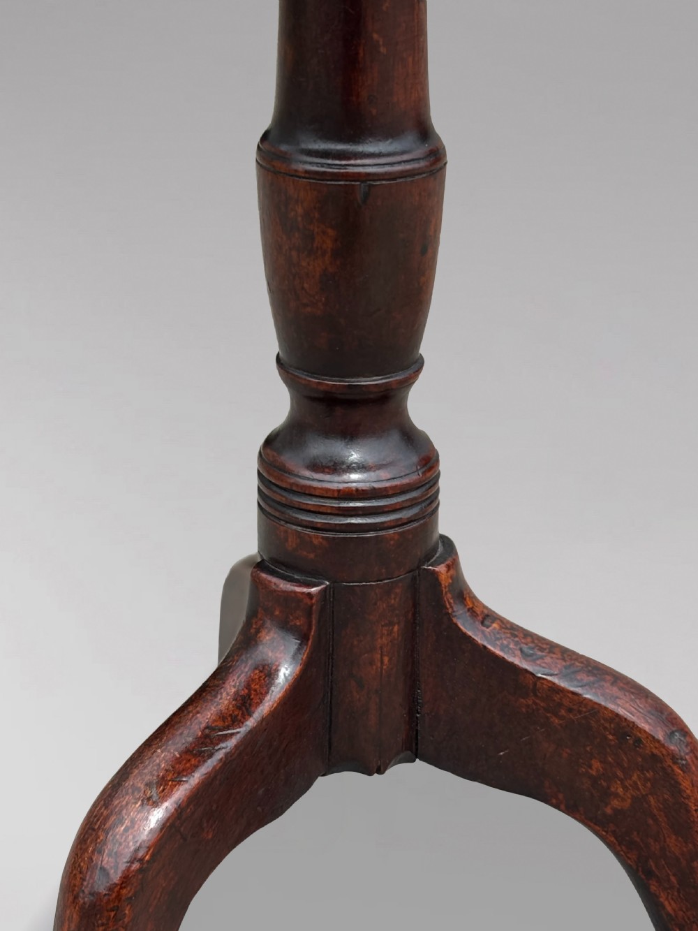 An 18th-century George III mahogany tripod table featuring an octagonal top, a central turned column, and three cabriole legs. View VI