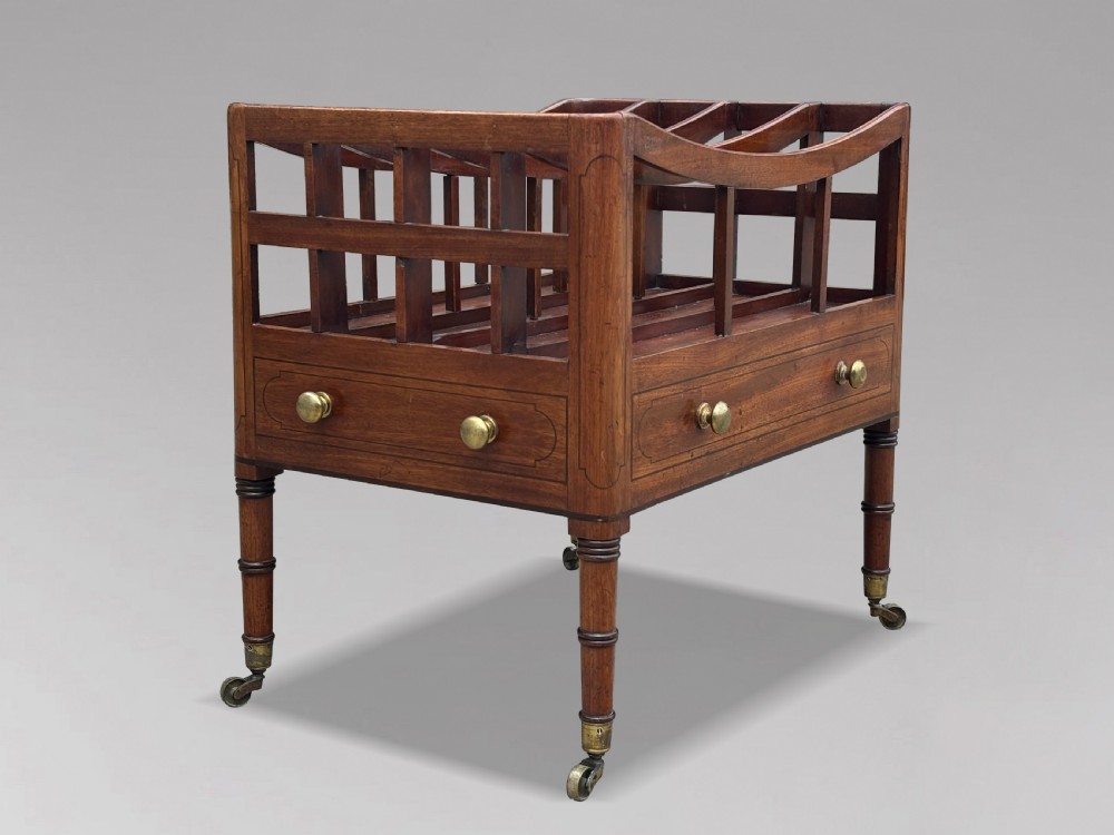 An 18th-century George III mahogany canterbury featuring slatted divisions, lower drawers with brass knobs, and turned legs on brass castors. View III