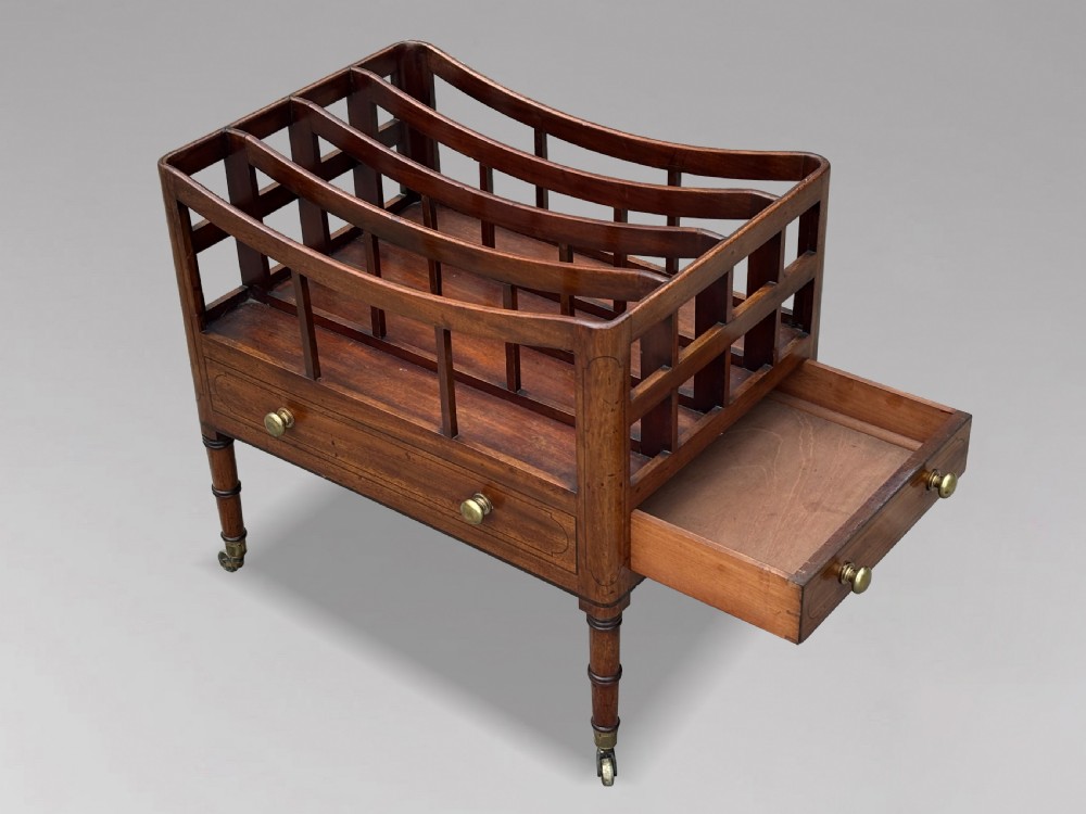 An 18th-century George III mahogany canterbury featuring slatted divisions, lower drawers with brass knobs, and turned legs on brass castors. View V