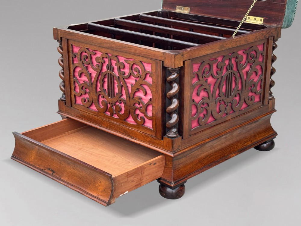 A Victorian rosewood piano stool featuring a square tapestry-upholstered top with green velvet edging, carved fretwork side panels, corner barley twist columns, and bun feet. View IX