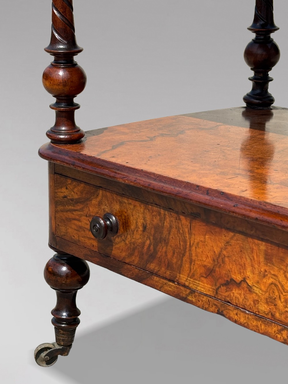 A Victorian walnut three-tier whatnot featuring barley twist supports, a single lower drawer, and brass castors. View IV
