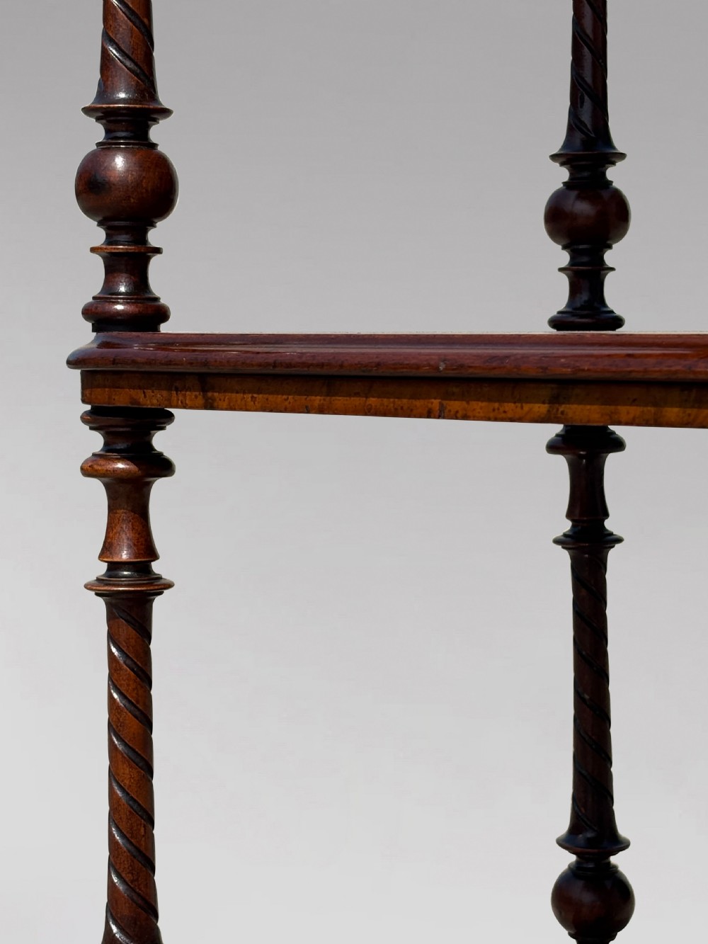 A Victorian walnut three-tier whatnot featuring barley twist supports, a single lower drawer, and brass castors. View VII