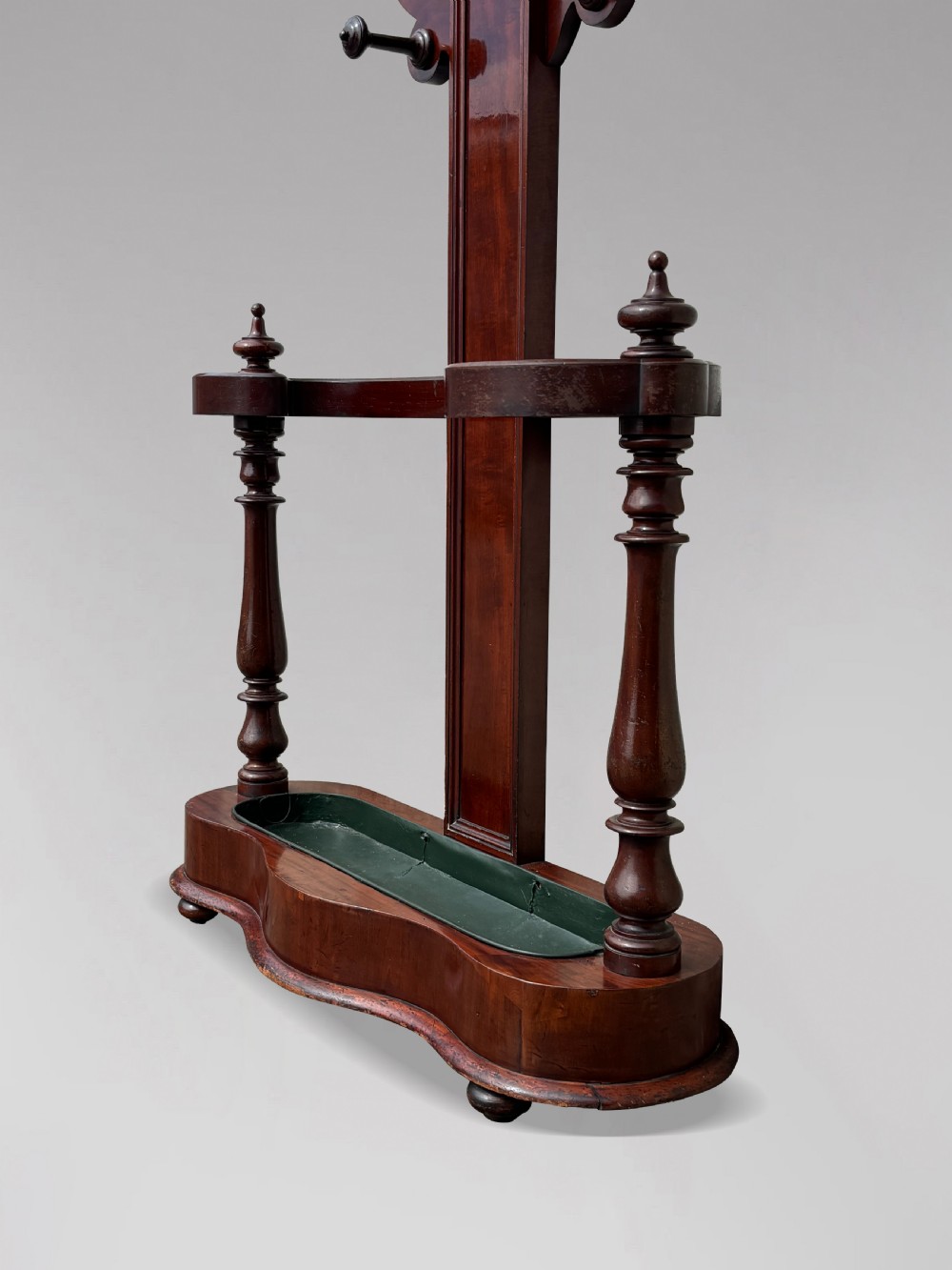 A 19th-century Victorian mahogany hall stand with carved coat pegs, turned supports, and an umbrella base featuring a green drip tray. View IV