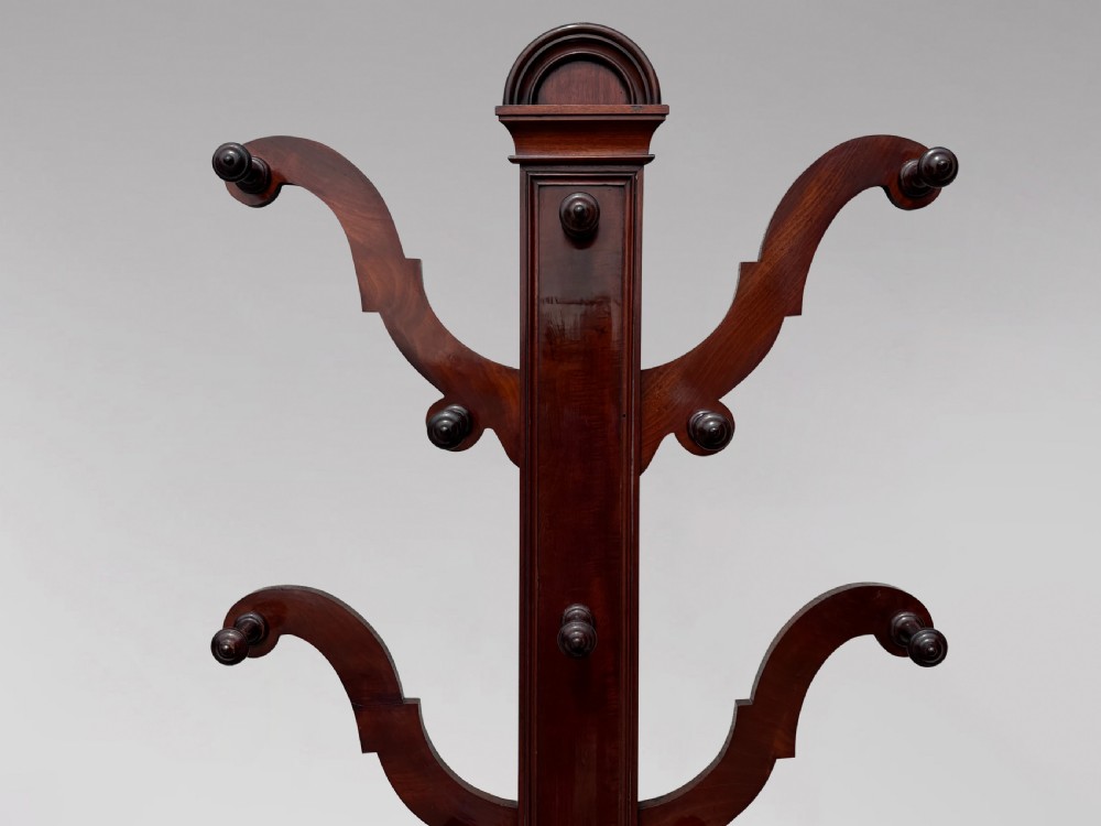 A 19th-century Victorian mahogany hall stand with carved coat pegs, turned supports, and an umbrella base featuring a green drip tray. View VII