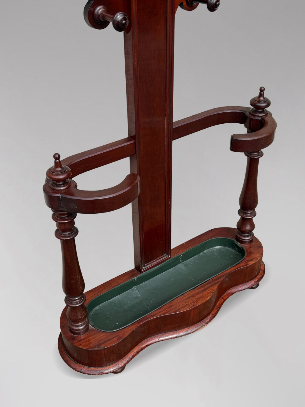 A 19th-century Victorian mahogany hall stand with carved coat pegs, turned supports, and an umbrella base featuring a green drip tray. View XI