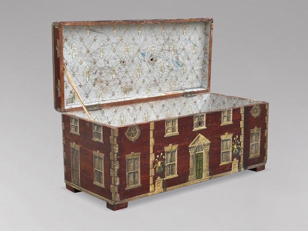 A rectangular dark red painted oak box decorated with a detailed Georgian house facade, featuring a brass handle on the top lid. View III