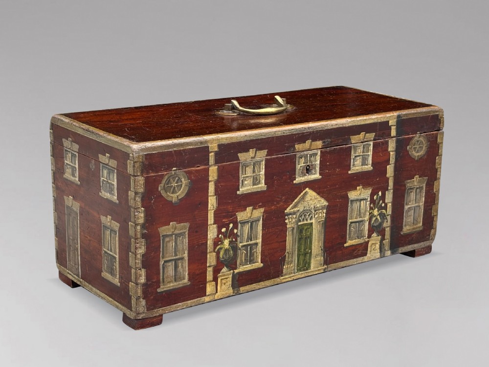 A rectangular dark red painted oak box decorated with a detailed Georgian house facade, featuring a brass handle on the top lid. View VI
