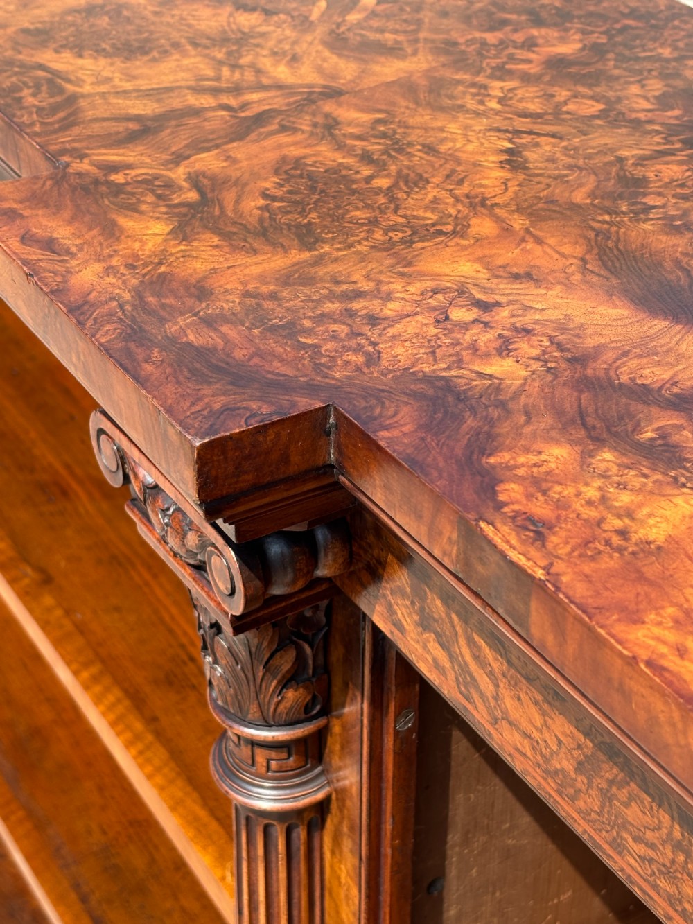 A low 19th-century William IV open bookcase crafted from burr walnut with two shelf sections flanked by carved pilasters. View III