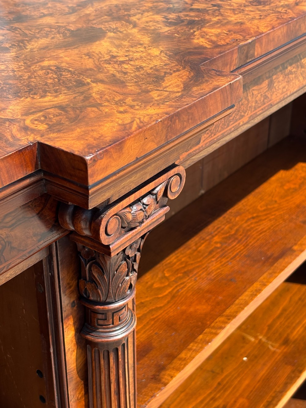 A low 19th-century William IV open bookcase crafted from burr walnut with two shelf sections flanked by carved pilasters. View XII