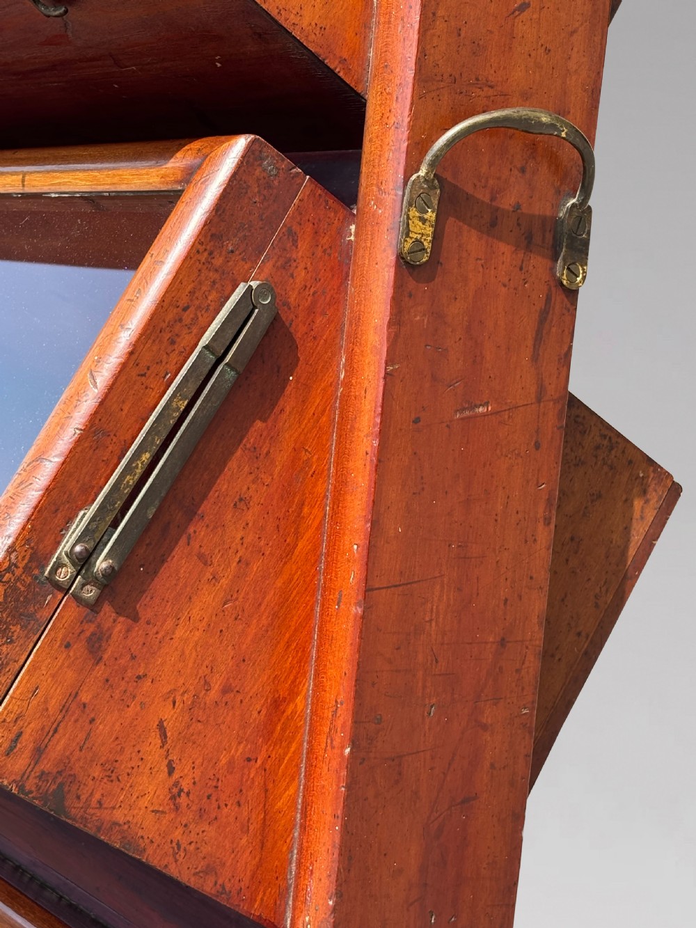 A late 19th-century mahogany three-tiered biscuit display cabinet featuring angled glass fronts, brass handles, and a painted advertising header for Mackenzies Biscuits. View IV
