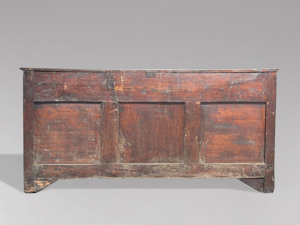 An 18th-century George II solid oak dresser base featuring multiple drawers, panelled cupboard doors, and brass drop handles. View VII