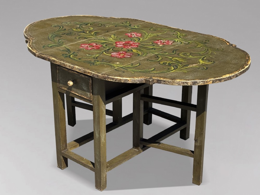 An early 20th-century Italian oval drop-leaf table painted in olive green with hand-painted red floral and green foliage motifs across the top surface.