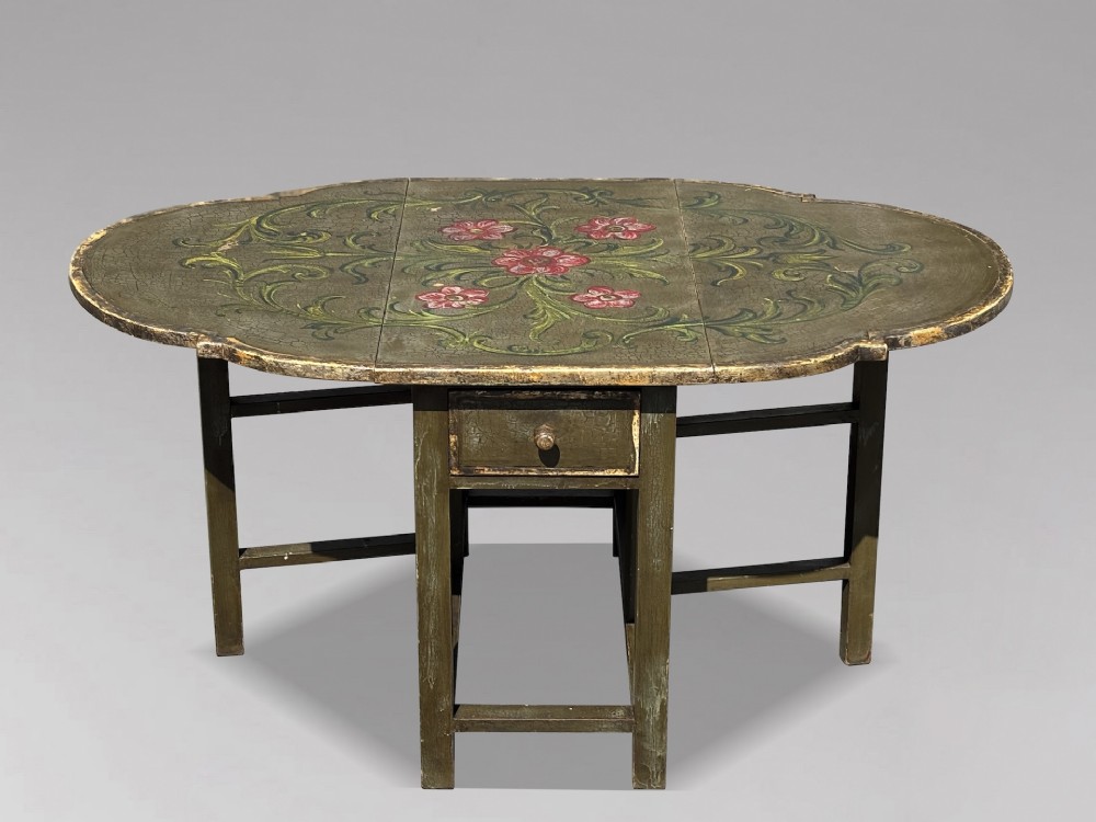 An early 20th-century Italian oval drop-leaf table painted in olive green with hand-painted red floral and green foliage motifs across the top surface. View II