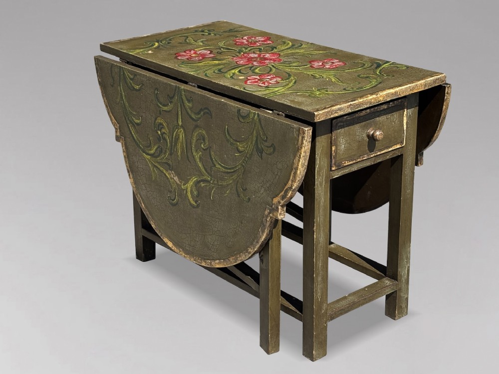 An early 20th-century Italian oval drop-leaf table painted in olive green with hand-painted red floral and green foliage motifs across the top surface. View IV