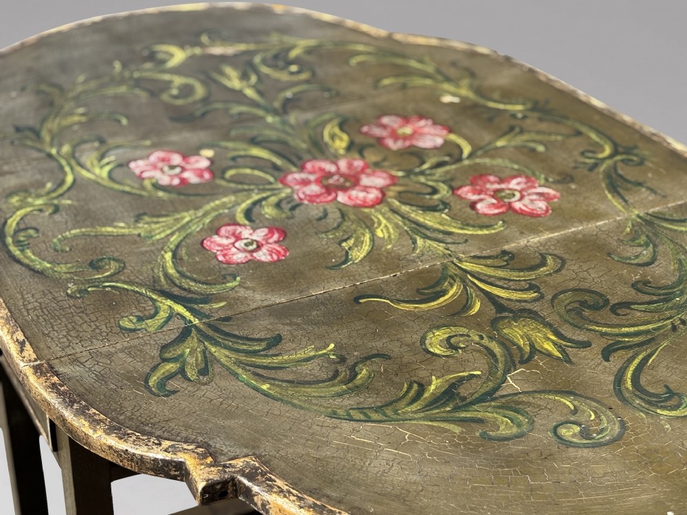 An early 20th-century Italian oval drop-leaf table painted in olive green with hand-painted red floral and green foliage motifs across the top surface. View VIII