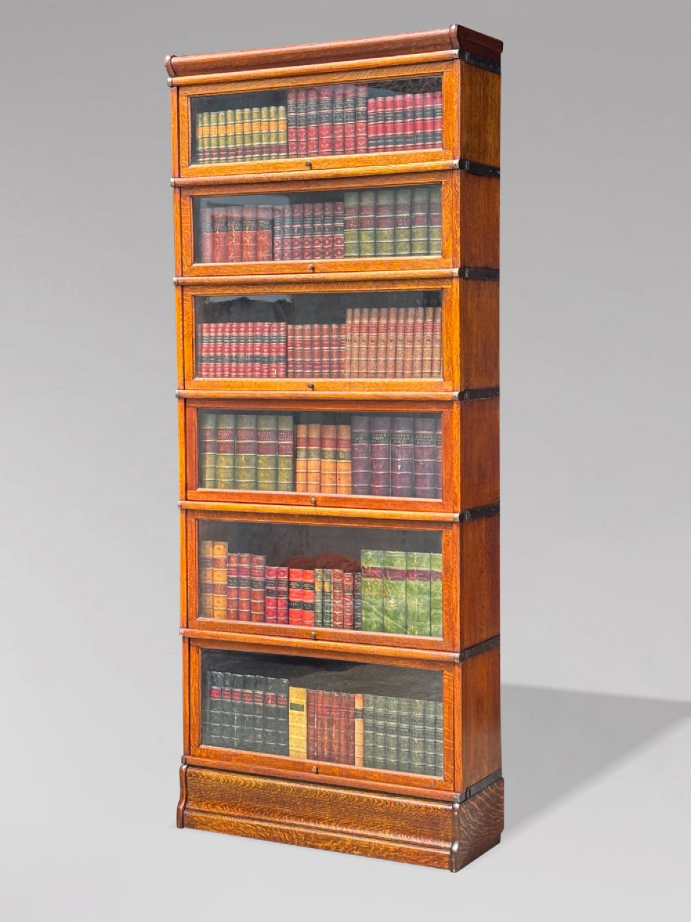 A tall late 19th-century six-tier oak Globe Wernicke bookcase with glazed up-and-over doors.