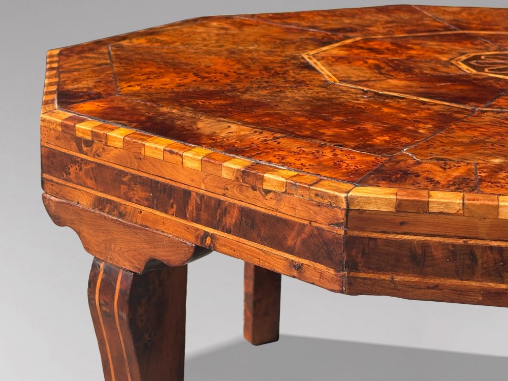 An octagonal 19th-century burr yew wood coffee table featuring radiating veneer panels, a central inlaid star motif, and a checkered border. View III
