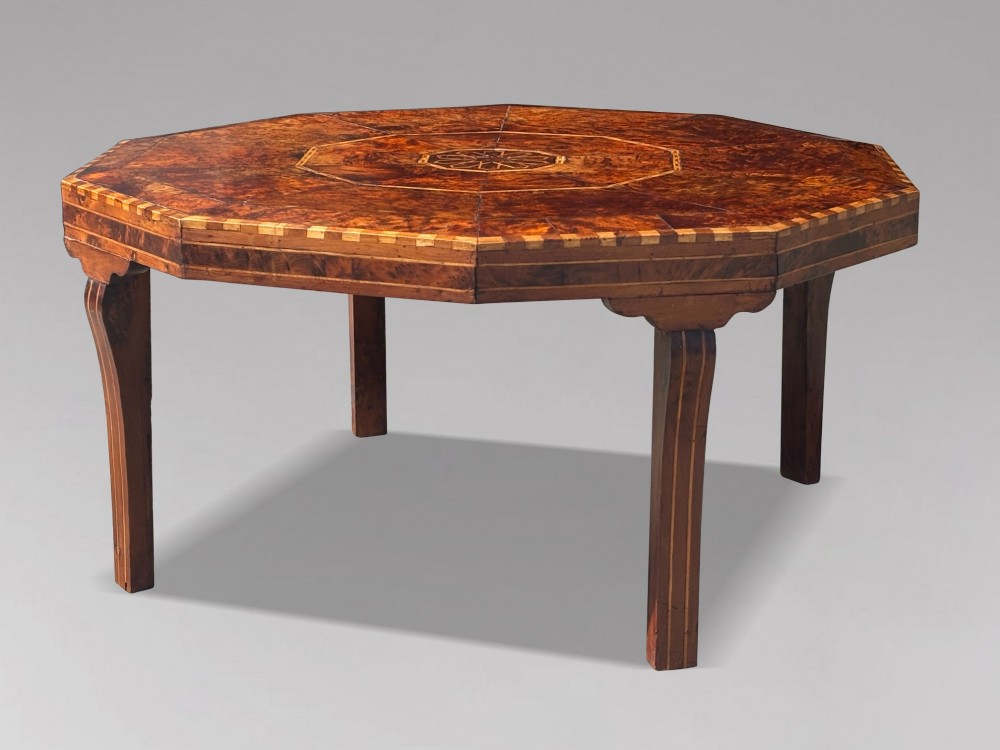 An octagonal 19th-century burr yew wood coffee table featuring radiating veneer panels, a central inlaid star motif, and a checkered border. View X